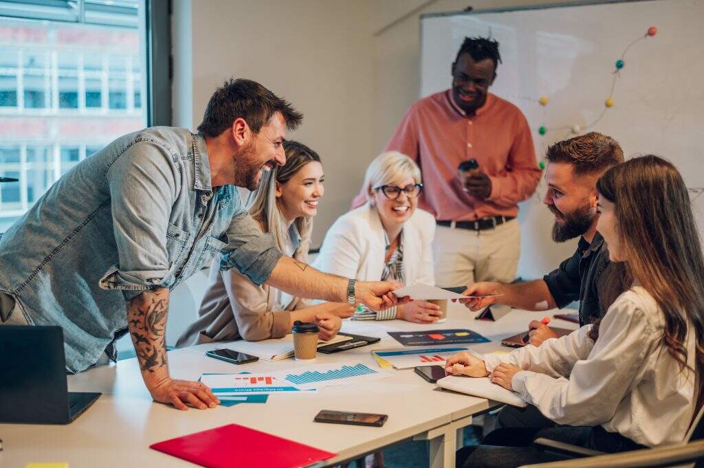 Grupo de pessoas alegres reunidas representando a cultura da empresa 